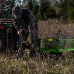 man attaching 2140GCG-NF filled with branches to ATV